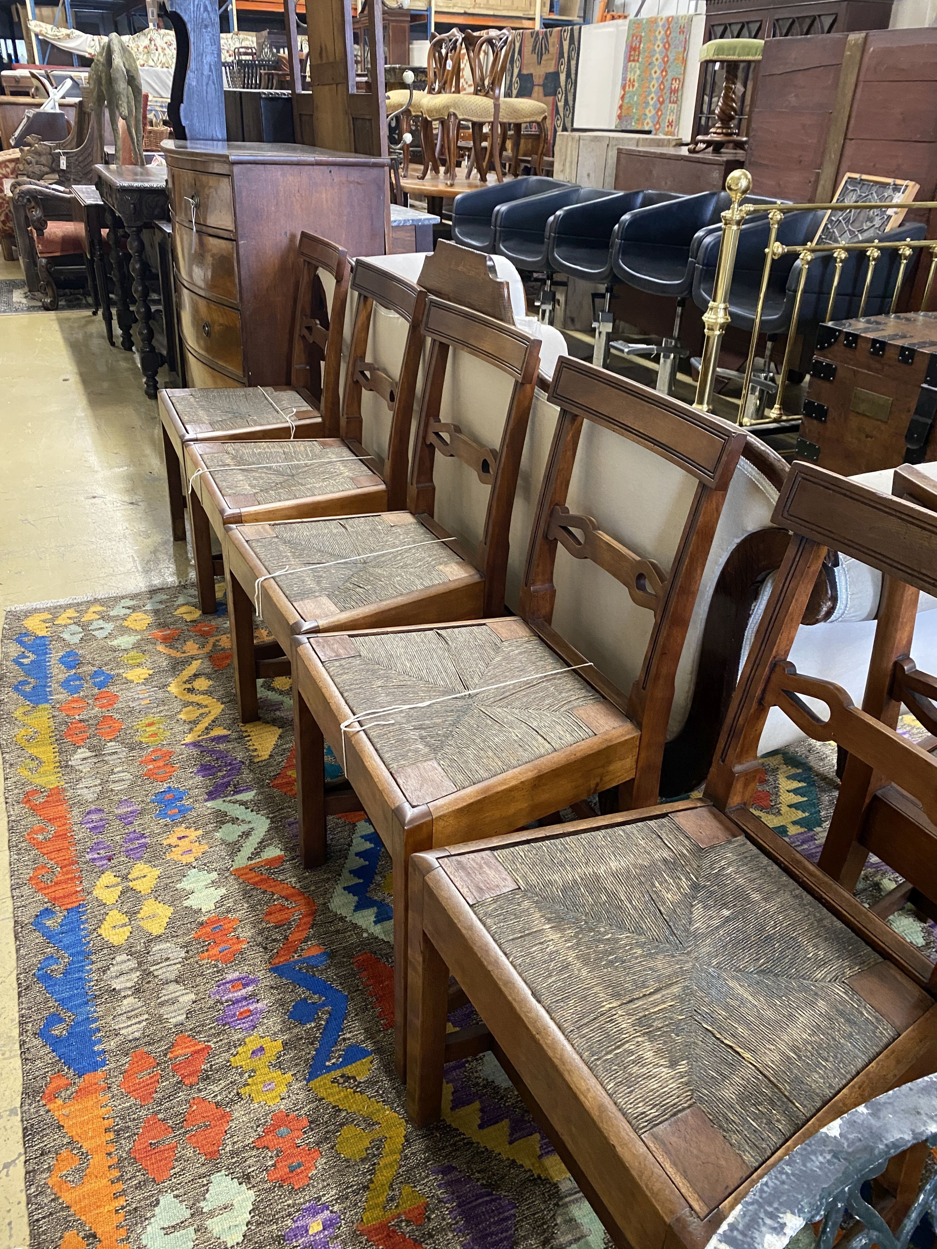 A set of six Regency provincial mahogany dining chairs with drop in rush seats